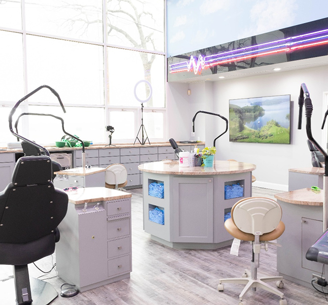 Modern orthodontic treatment room with dental chair, equipment, and bright natural lighting from windows.